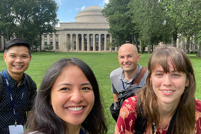 Four students smile with the MIT Dome in the background