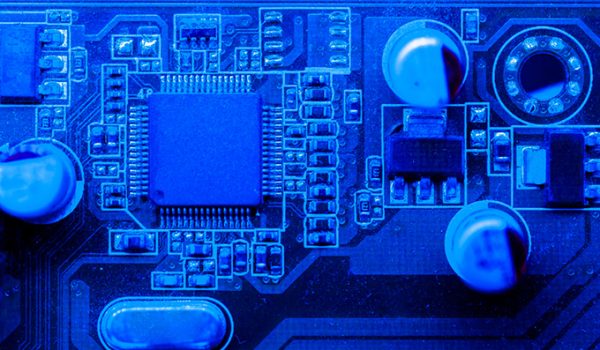 A close-up of a motherboard's circuitry, tinted a deep blue.