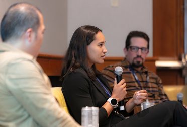 Noemie Midrez speaks while Tim Chiang and Jeremy Katz look on