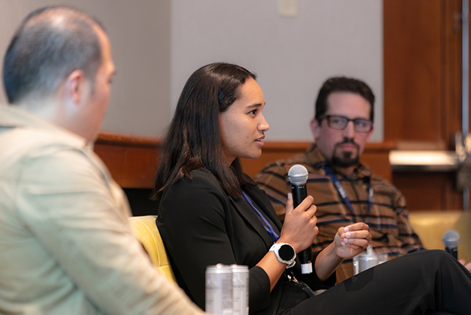 Noemie Midrez speaks while Tim Chiang and Jeremy Katz look on