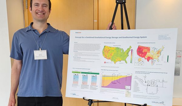 David Brown stands beside a colorful research poster