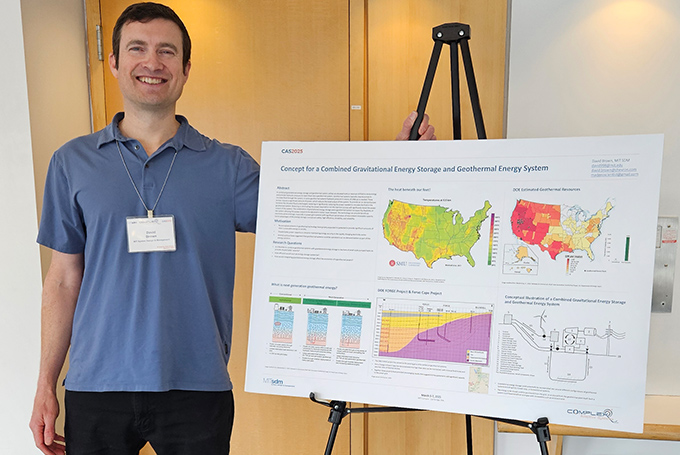 David Brown stands beside a colorful research poster