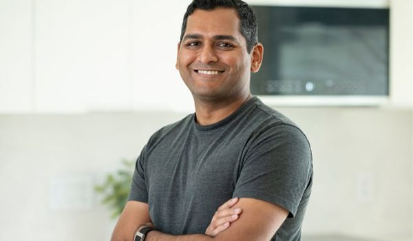Headshot of Vikas Enti, with arms folded and a smile on his face.