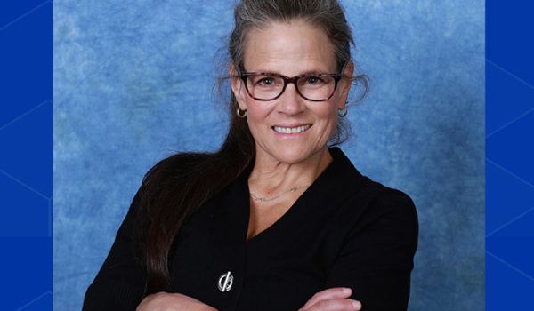 A headshot of Christine Miyachi, arms folded and giving a confident smile to the camera.