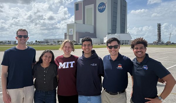 A group of students stand in front of NASA's Kennedy Space Center