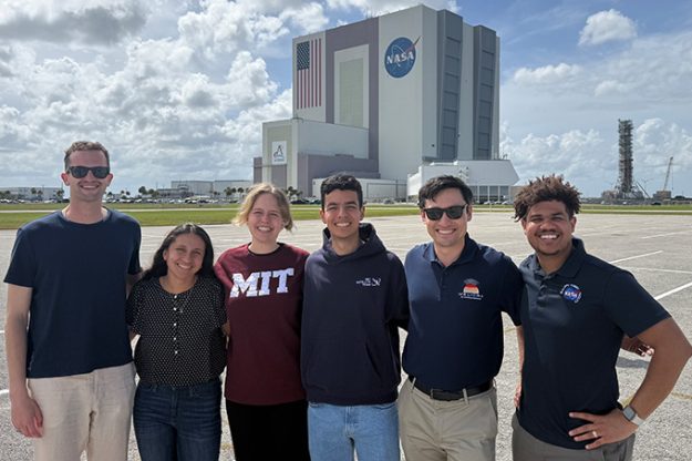 A group of students stand in front of NASA's Kennedy Space Center